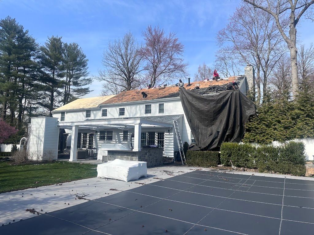 Catch tarps hung off a colonial roof to protect the driveway and patio during tear-off