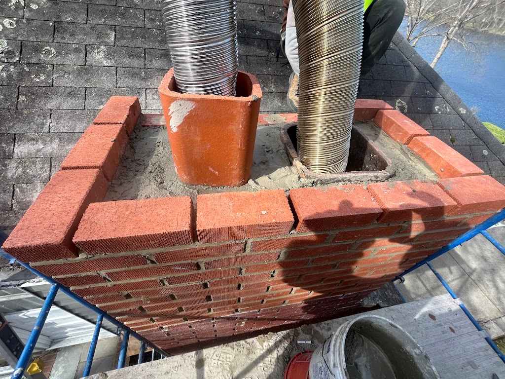 Top of a rebuilt brick chimney with a new clay flue tile and a stainless steel flue liner
