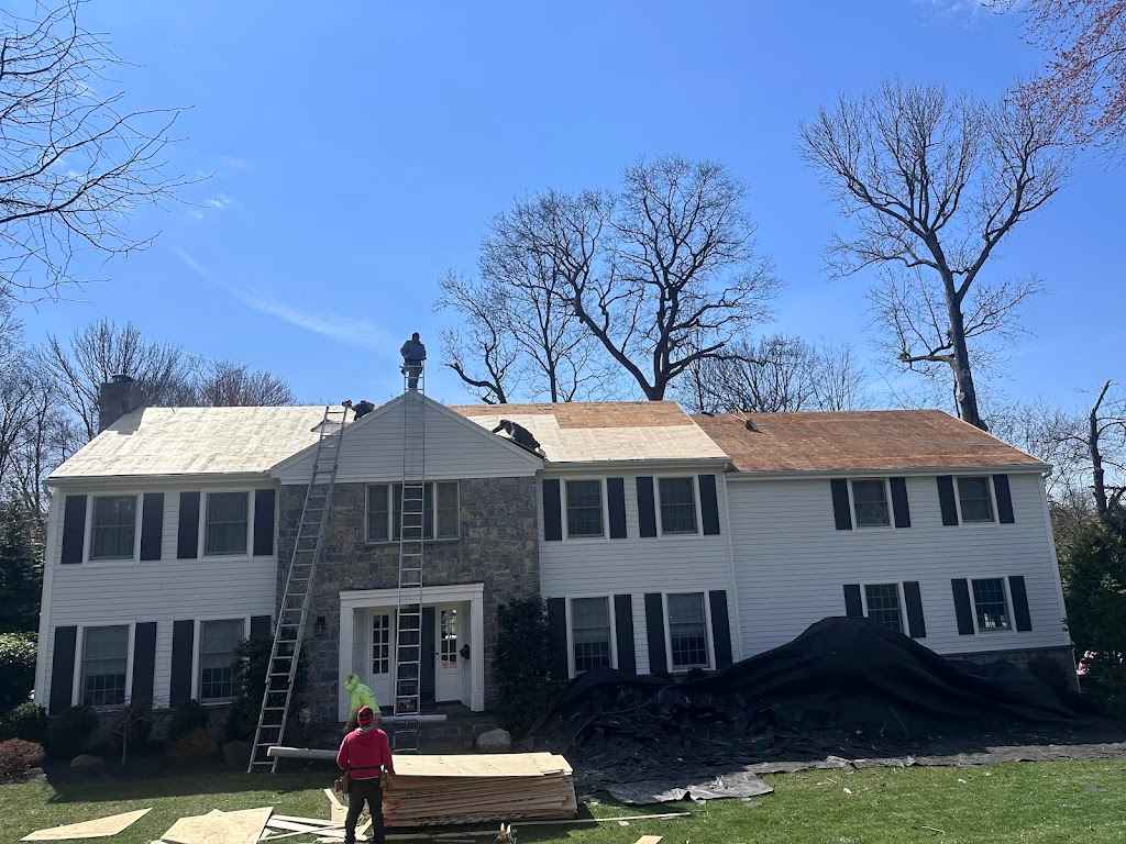 Two-story colonial home mid roof replacement with ladders, new plywood and protective tarps
