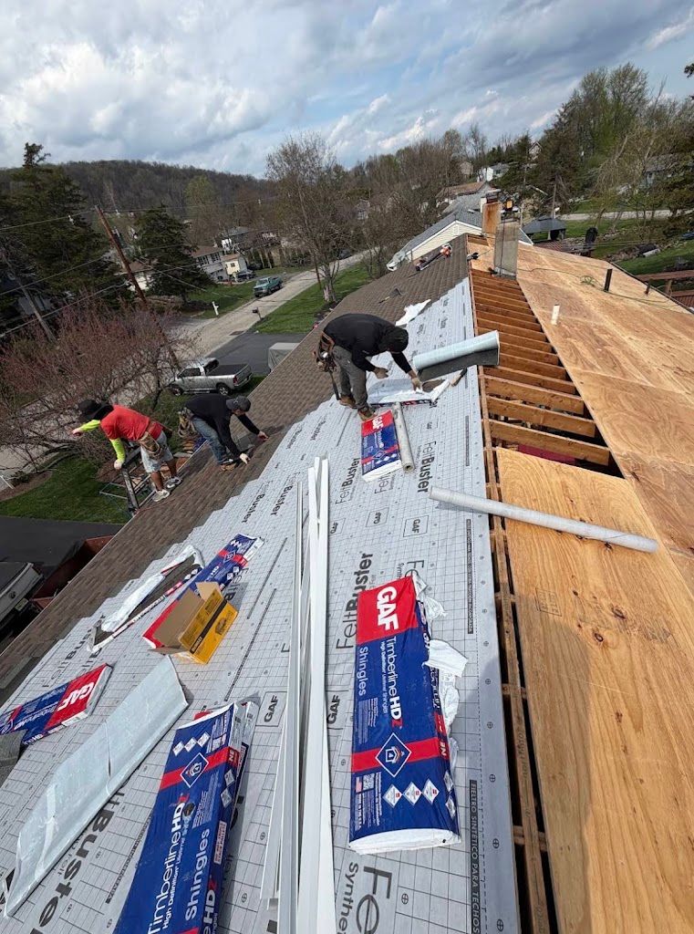 Roofing crew rolling out synthetic underlayment over new plywood decking