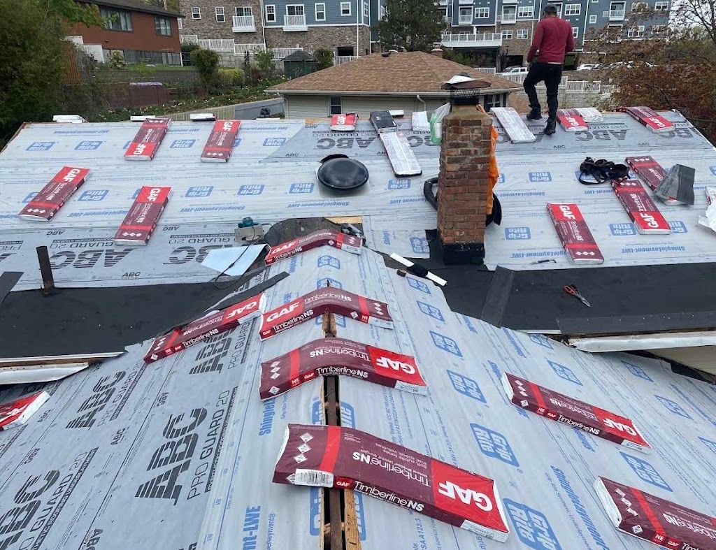 Synthetic underlayment and ice and water barrier installed around a brick chimney during a roof replacement